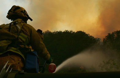 
                    A Los Angeles City firefighter douses a brush fire from atop his fire truck in the city's sprawling Griffith Park, on May 8, 2007, as dangerously hot and dry conditions plagued Southern California.
                                            (Robyn Beck / AFP / Getty Images)
                                        