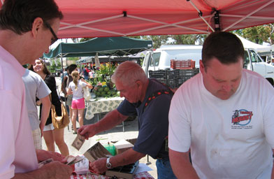 
                    George Sims (center) took up cherry farming after he retired. The whole family helps staff the farmers markets.
                                            (Pat Loeb)
                                        