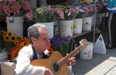 
                    The Victory Park market does allow non-amplified music. Pepe, a blind guitar player and soulful singer from Oaxaca, Mexico, is a regular fixture.
                                            (Pat Loeb)
                                        