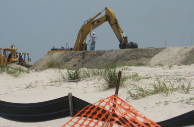 
                    Contractors for the Army Corps of Engineers are building a dune to protect the beach.
                                            (Eve Troeh)
                                        