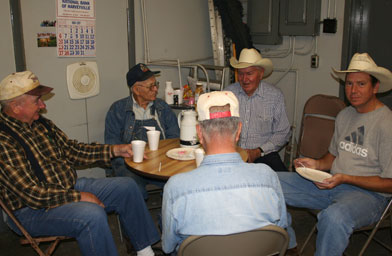 
                    Harveyville local Bing Miller (in striped shirt and cowboy hat) sits with friends at a regular grits and gravy breakfast at the local grocery.
                                            (Frank Morris)
                                        