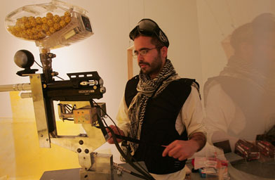 
                    Participants can log onto the Internet to watch and shoot paintballs at Bilal as he lives in the installation during the month of May. Here he loads paintballs into a gun.
                                            (Scott Olson / Getty Images)
                                        