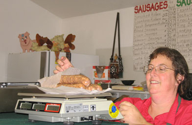 
                    Maria Watson started Valley Hungarian sausage shop with her immigrant parents in the 1980s. Here she weighs some Swedish potato links for a customer.
                                            (Eve Troeh)
                                        