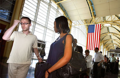 
                    Taylor Hoffman (left) and Katrina Edge wait in line to check in for their flight to New York City at a Washington D.C. airport. Their Memorial Day weekend was the start of what's expected to be a very busy season.
                                            (Chip Somodevilla / Getty Images)
                                        