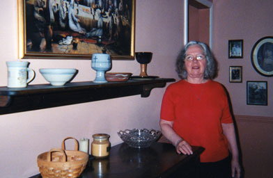 
                    Houk poses for a photo with a painting of the Last Supper.
                                            (Joan Houk)
                                        