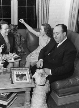 
                    Director Alfred Hitchcock (right), his wife Alma Reville, (far left), their daughter Patricia Hitchcock, and their dogs at their California home, ca. 1941.
                                            (The Margaret Herrick Library)
                                        