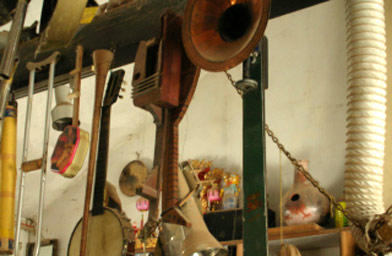 
                    Musical instruments Bobby has made over the years.  They hang from the rafters inside his house.
                                            (Ann Heppermann)
                                        