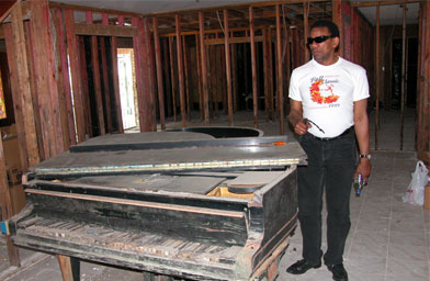 
                    Henry Butler poses with his water-logged piano.
                                            (Stephen Smith)
                                        