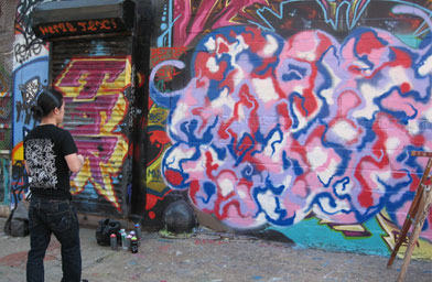 
                    A Five Pointz contributer puts the finishing touches on his piece.
                                            (Laura Starecheski)
                                        