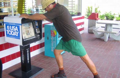 
                    Nathan Deuel, stretching on a USA Today vending box in front of McDonald's in Brunswick, Georgia.
                                            (Kelly McEvers)
                                        