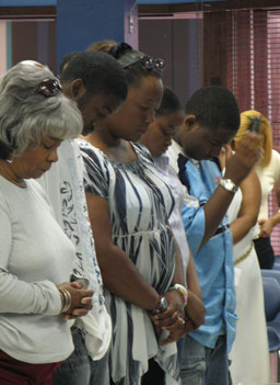 
                    Worshippers in prayer at a church service in Randall Park Mall.
                                            (Mhari Saito)
                                        