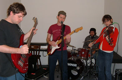 
                    Dave Fischoff with his backing band during rehearsal. From L - R: Matt Hallock--bass, Dave Fischoff--guitar & vocals, Chris Kolodziej--drums, and Whitney Johnsan--viola.
                                            (Blair Chavis)
                                        