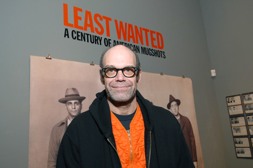 
                    Mug shot collector Mark Michaelson has his own mug shot taken during opening night of his show.
                                            (Cheri Eisenberg)
                                        