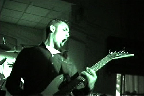 
                    Faisal, rhythm guitarist and lead singer of Acrassicauda performing in a Baghdad social club, January 2004.
                                            (VBS.TV/VICE Films)
                                        