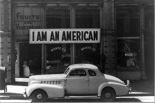 
                    A sign reading "I am an American" was placed in a store window in San Francisco, Calif., on December 8, 1941, the day after Japan attacked Pearl Harbor. The store was closed following government orders that people of Japanese descent evacuate certain West Coast areas.
                                            (Dorathea Lange)
                                        