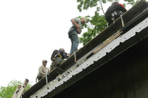 
                    Volunteers working on the roof set the final solar tubes in place.
                                            (Shannon Mullen)
                                        