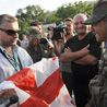 A Georgian journalist offers a flag to soldier