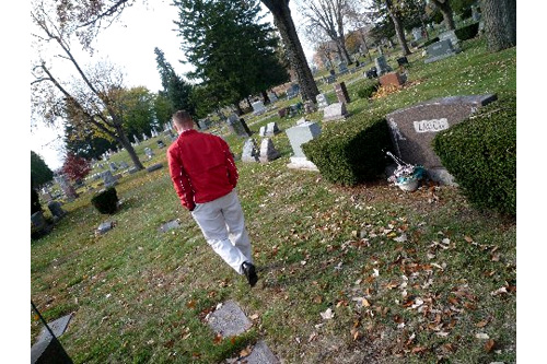 
                    Doug Merrill walks through Oak Grove Cemetery, where more than a half-dozen people rest who were victims of suicide. He comes to the cemetery often to visit Dawn's grave. She was his best friend in high school when she took her life just days after a member of the wrestling team committed suicide.
                                            (Desiree Cooper)
                                        