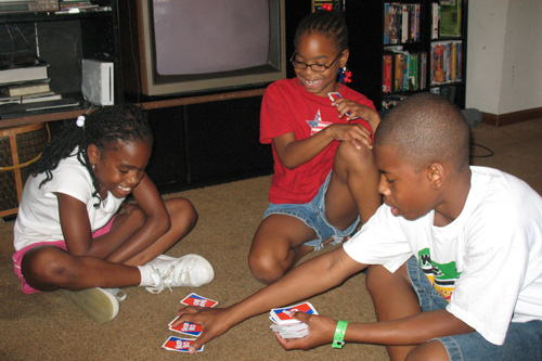
                    Nia,9, Ayanna, 7 and Mark Jr. play Skip Bo in the living room of their old house.  Nia won.
                                            (Laurie Stern)
                                        